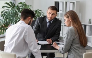 Unhappy young couple visiting divorce lawyer in office