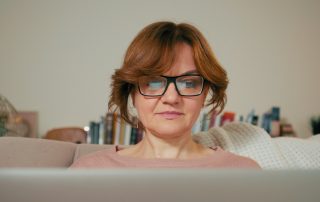 Staying safe in an online world: Beautiful Lady with Laptop in a Cozy Room.