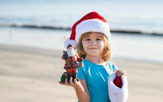 Image of a boy wearing a Santa hat, accompanying family law article "The 10 Do’s and Don’ts of Family Law for Christmas"