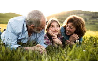 Image of a senior couple with granddaughter outside accompanying family law article "Grandparents, babysitting, and property settlements"