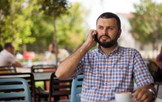 Image of a man using phone in cafe, accompanying family law article "Do’s and don’ts on accessing your ex’s financial documents"