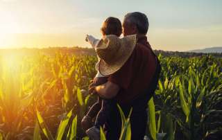 Image of a farmer with his child, accompanying family law article "Who gets the family farm?"